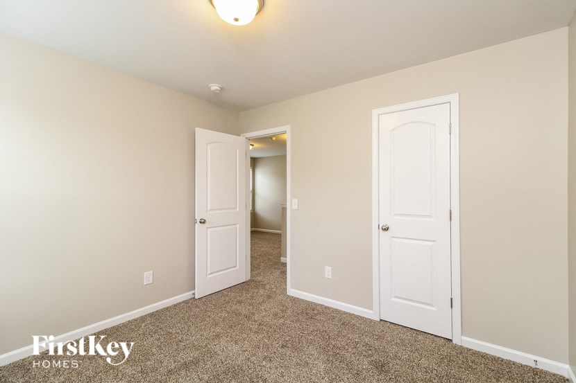 A room with two white doors and a carpeted floor.