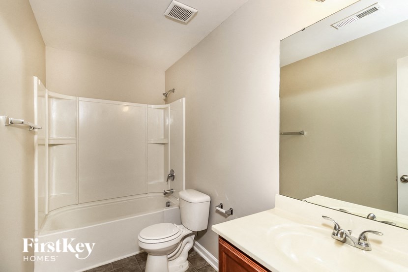 A white bathroom with a toilet, sink, and shower.
