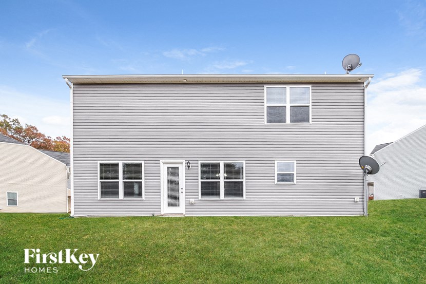 A grey house with a satellite dish on the roof.