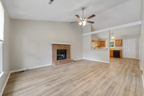 A living room with a fireplace and a ceiling fan.