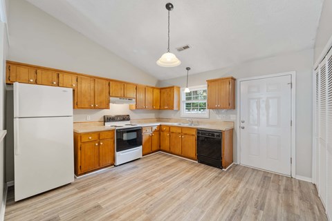 A kitchen with wooden cabinets and a white refrigerator.
