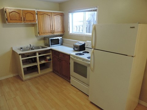 A kitchen with wooden cabinets and a white refrigerator.