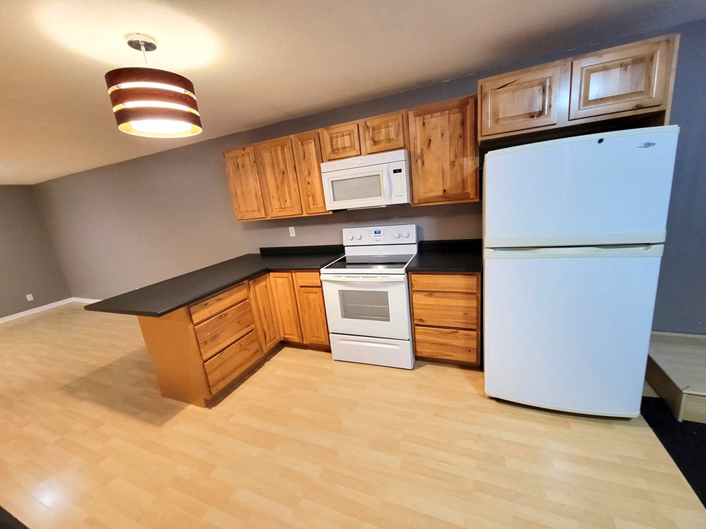 a kitchen with white appliances and wooden cabinets