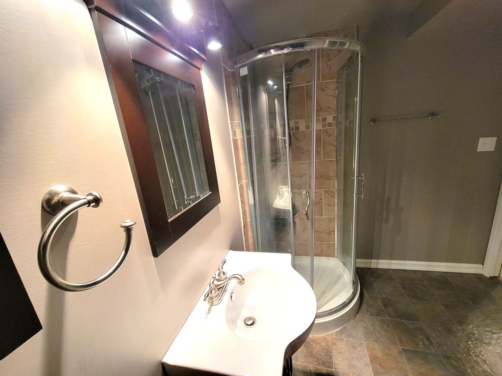 a bathroom with a shower and a sink and a toilet