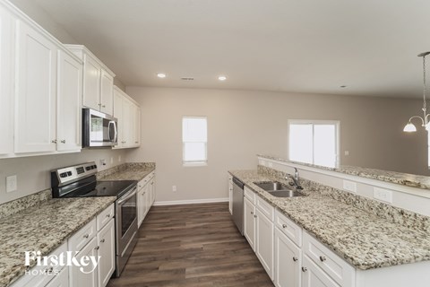 a large kitchen with white cabinets and granite counter tops