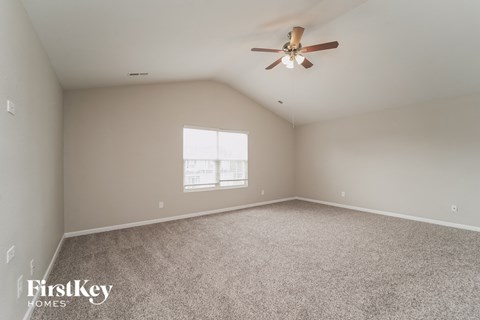a bedroom with carpet and a ceiling fan