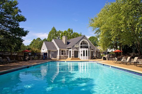 a swimming pool with a house in the background