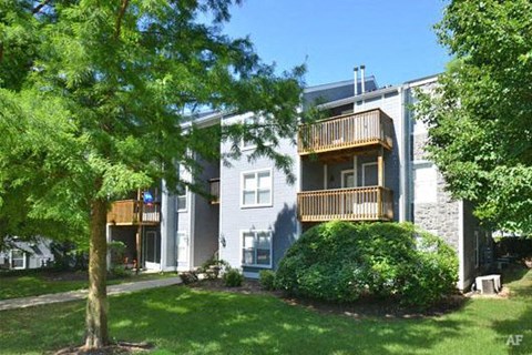 an apartment building with a tree in front of it
