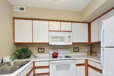 a kitchen with white appliances and white cabinets