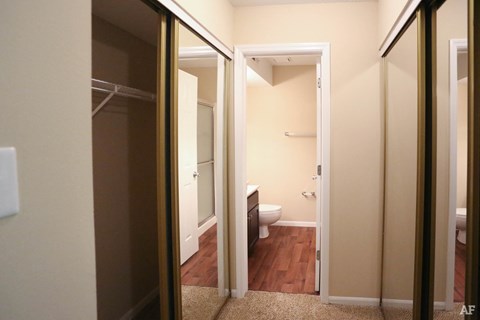 a bathroom with a mirror closet and a toilet