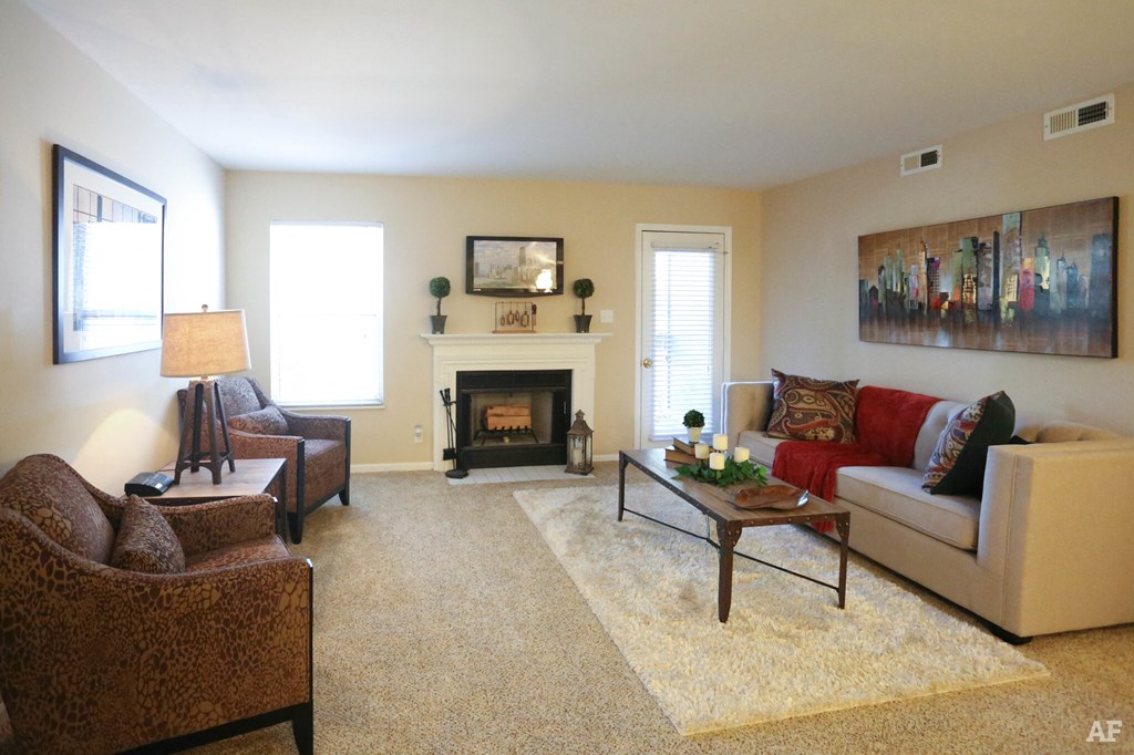 a living room with a couch and chairs and a fireplace