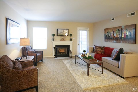 a living room with a couch and chairs and a fireplace