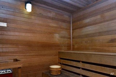 a wooden sauna with a wooden bench and a stool