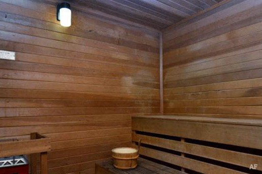 a wooden sauna with a wooden bench and a stool