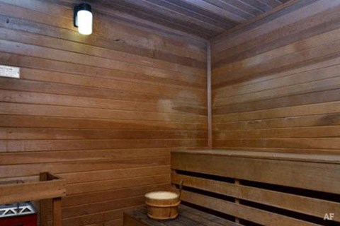a wooden sauna with a wooden bench and a stool