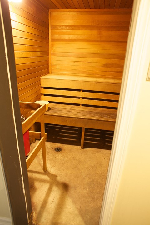 a sauna with wooden benches in a room with a door