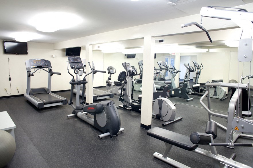a gym with various cardio machines and weights