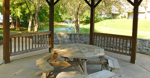 a picnic table on a porch with a lake in the background
