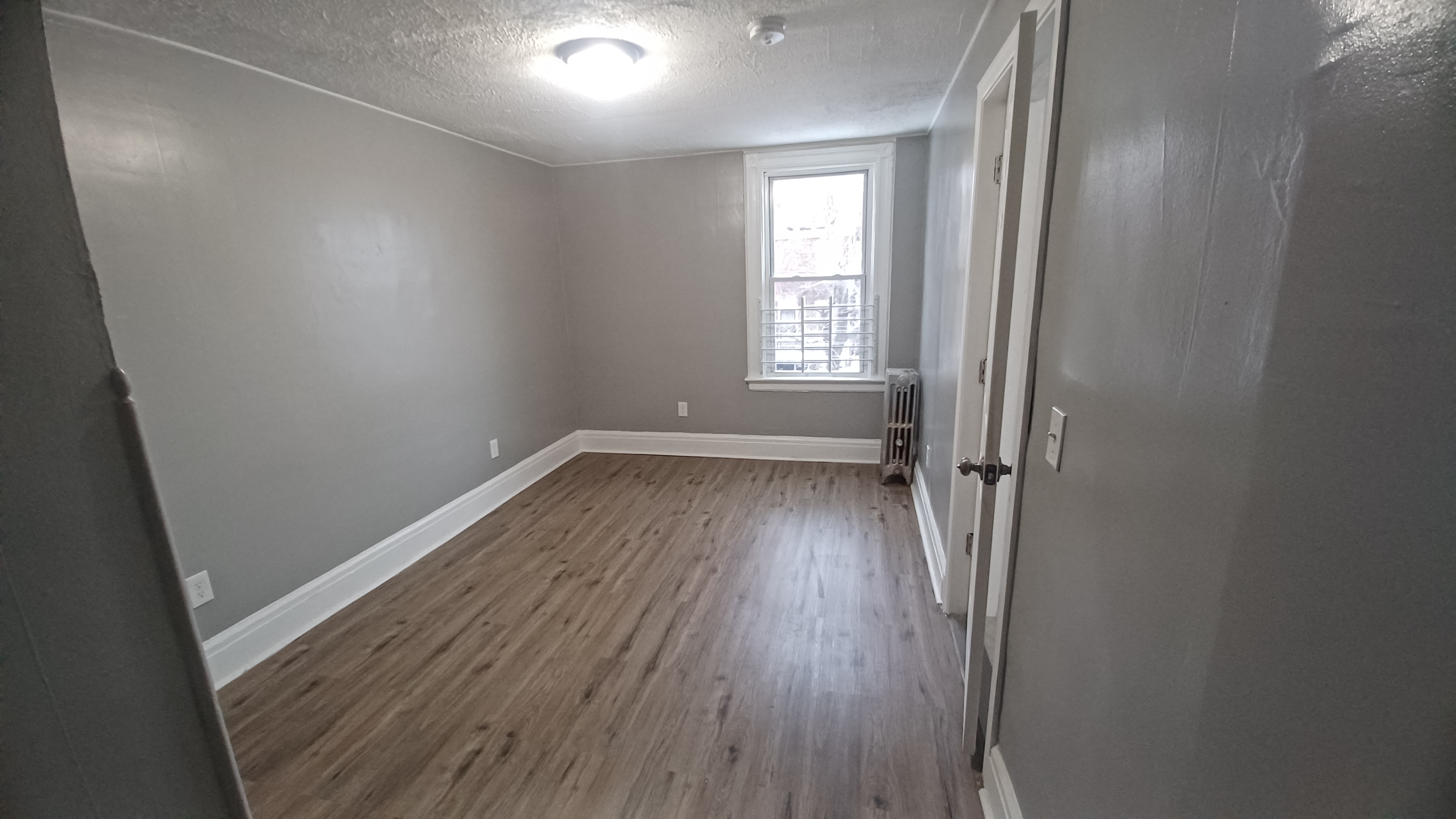 A room with wooden floors and a window.