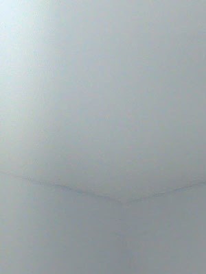 A room with a white door and a white wall.