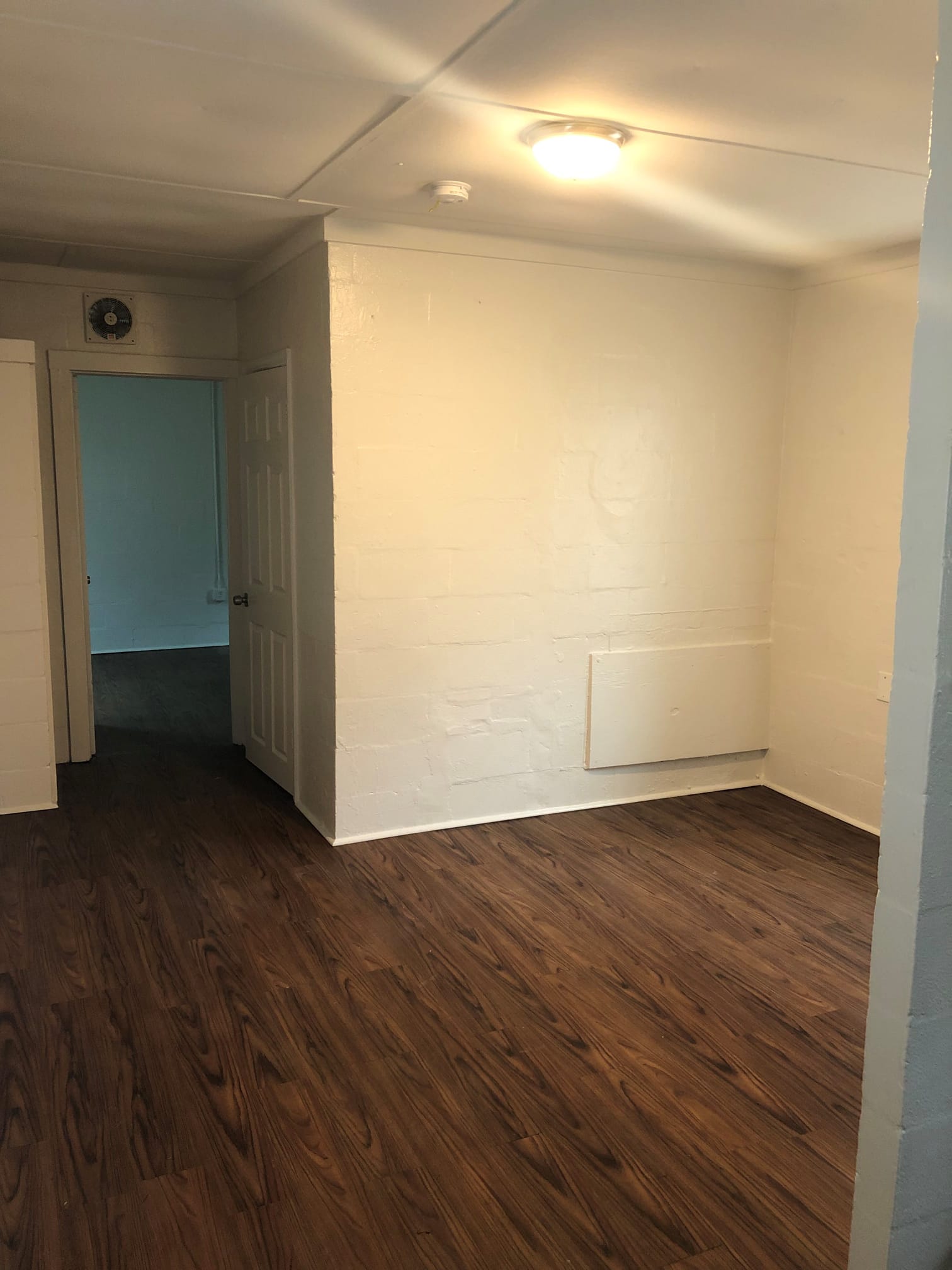 A room with a wooden floor and a white wall.