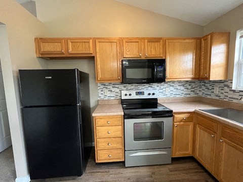a kitchen with a stove refrigerator and microwave