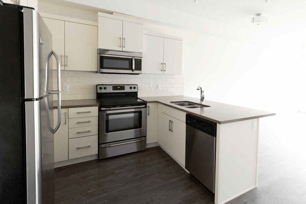 a kitchen with white cabinets and stainless steel appliances