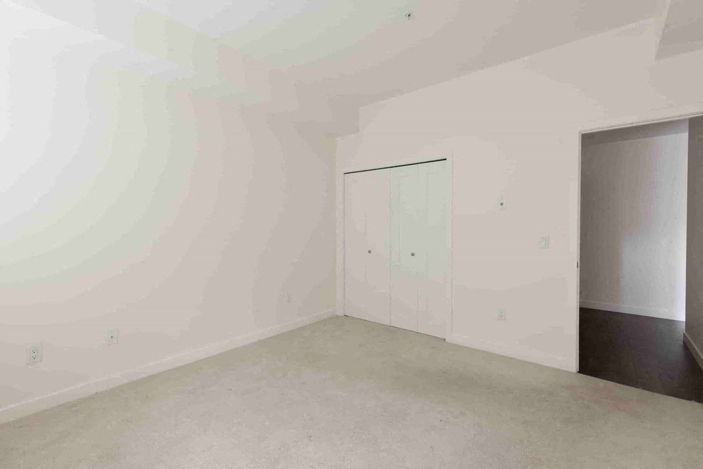 an empty room with white walls and a closet