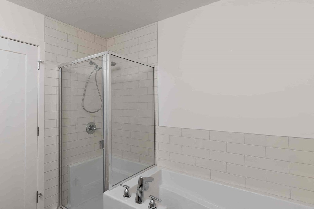 a white bathroom with a shower and a sink