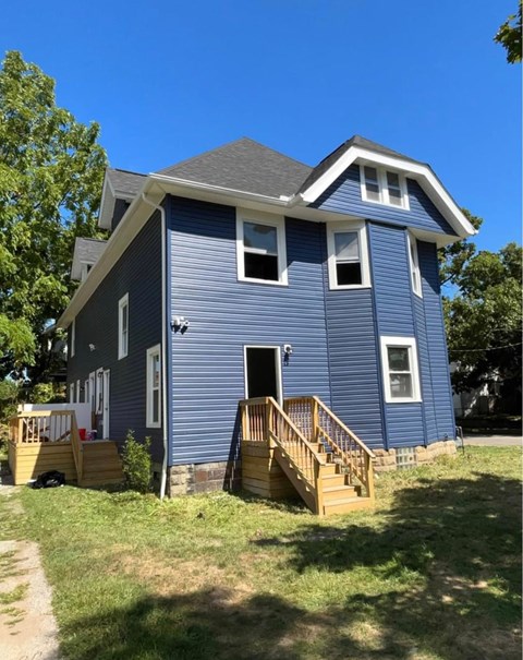 A blue house with a white trim and a small porch.