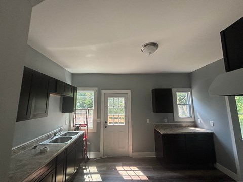 A kitchen with a sink, stove, and countertop.