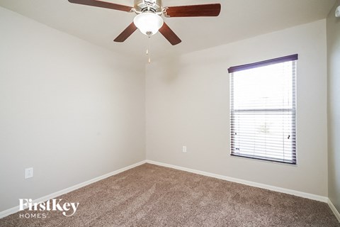 a bedroom with a ceiling fan and a window