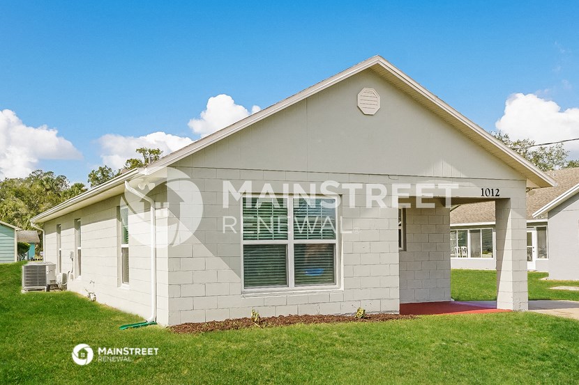 a small white house with a lawn in front of it