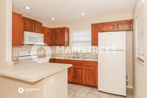a kitchen with white appliances and wooden cabinets
