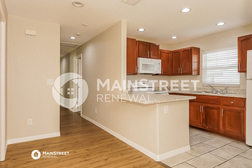 a kitchen with an island and wooden floors and cabinets