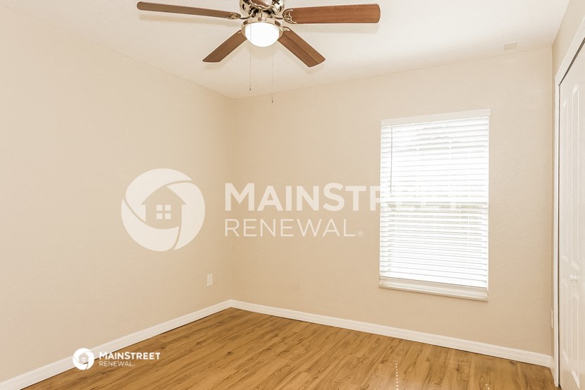interior of an empty room with a ceiling fan