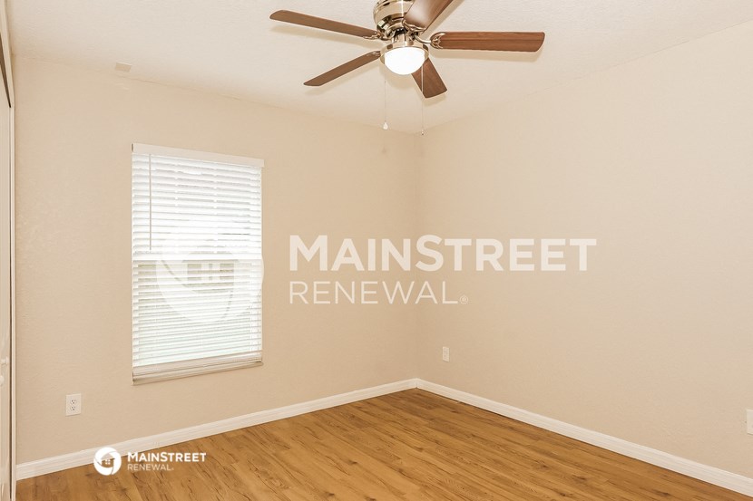 a bedroom with a ceiling fan and a window