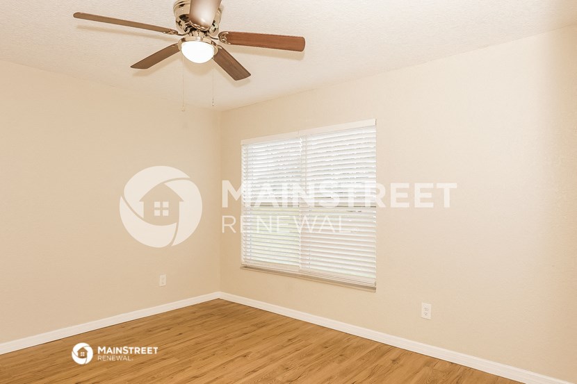 a bedroom with a ceiling fan and a window