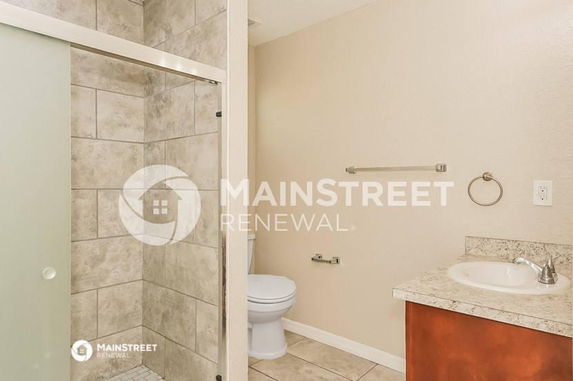 a bathroom with a toilet and a sink and a shower