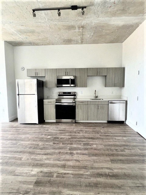 an empty kitchen with a refrigerator and a stove