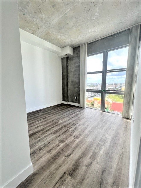 an empty living room with wood floors and a window
