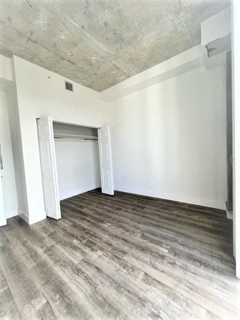 an empty living room with white walls and wood floors
