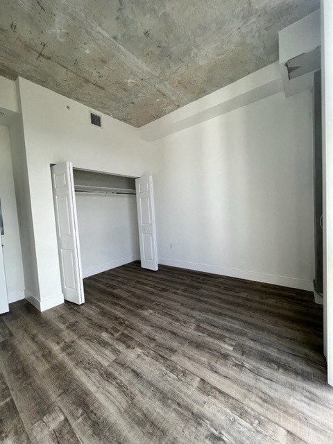 an empty living room with white walls and wood floors
