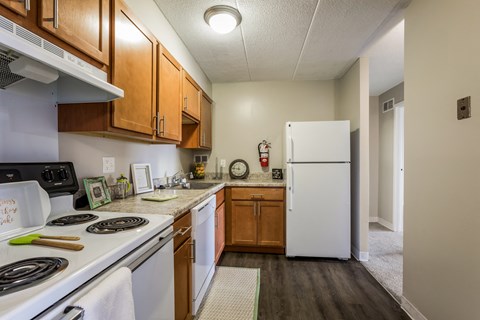 A kitchen with a white fridge and wooden cabinets.