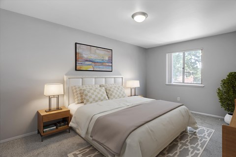 A bedroom with a bed, nightstand, and a painting on the wall.