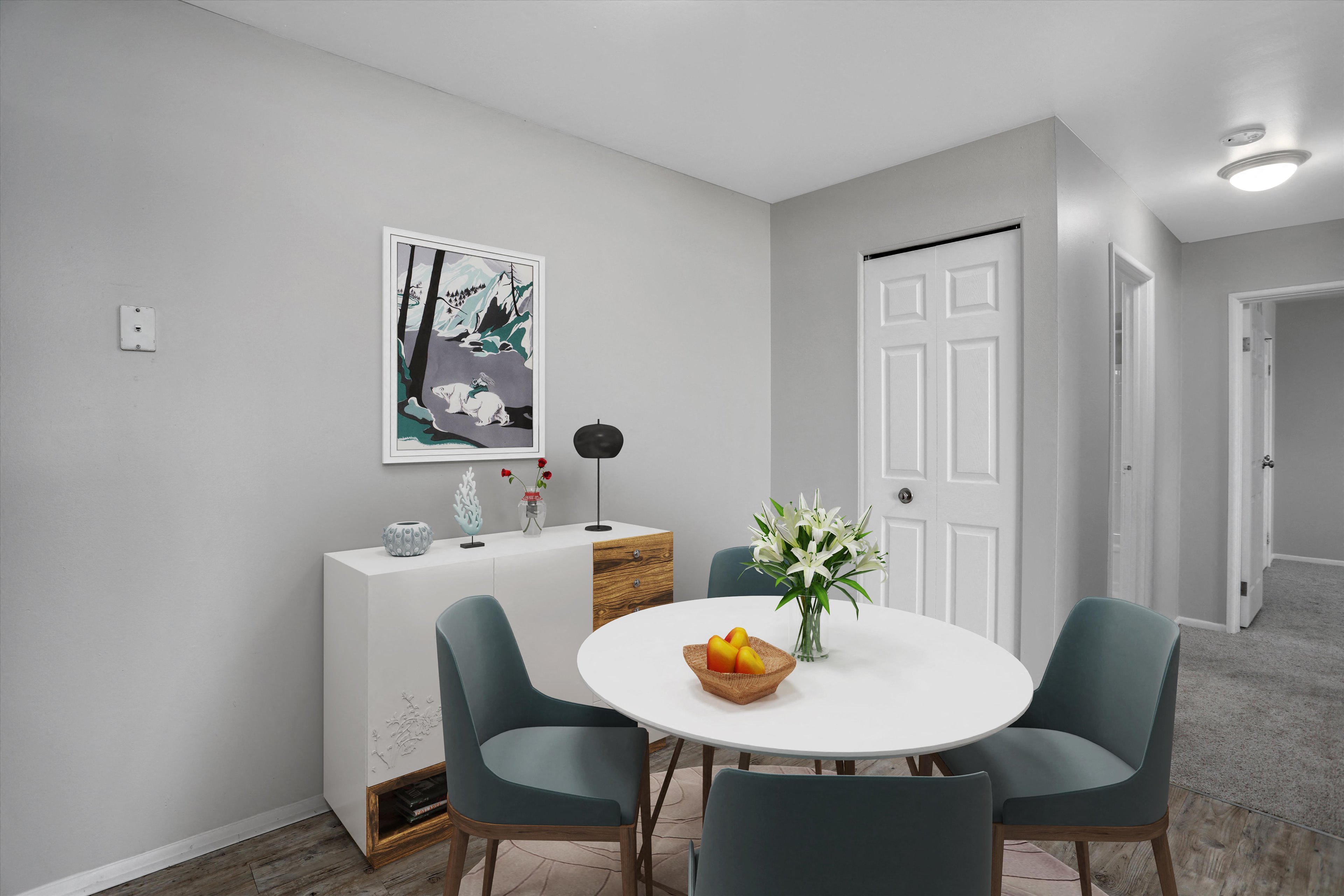 A dining room with a white table and chairs.
