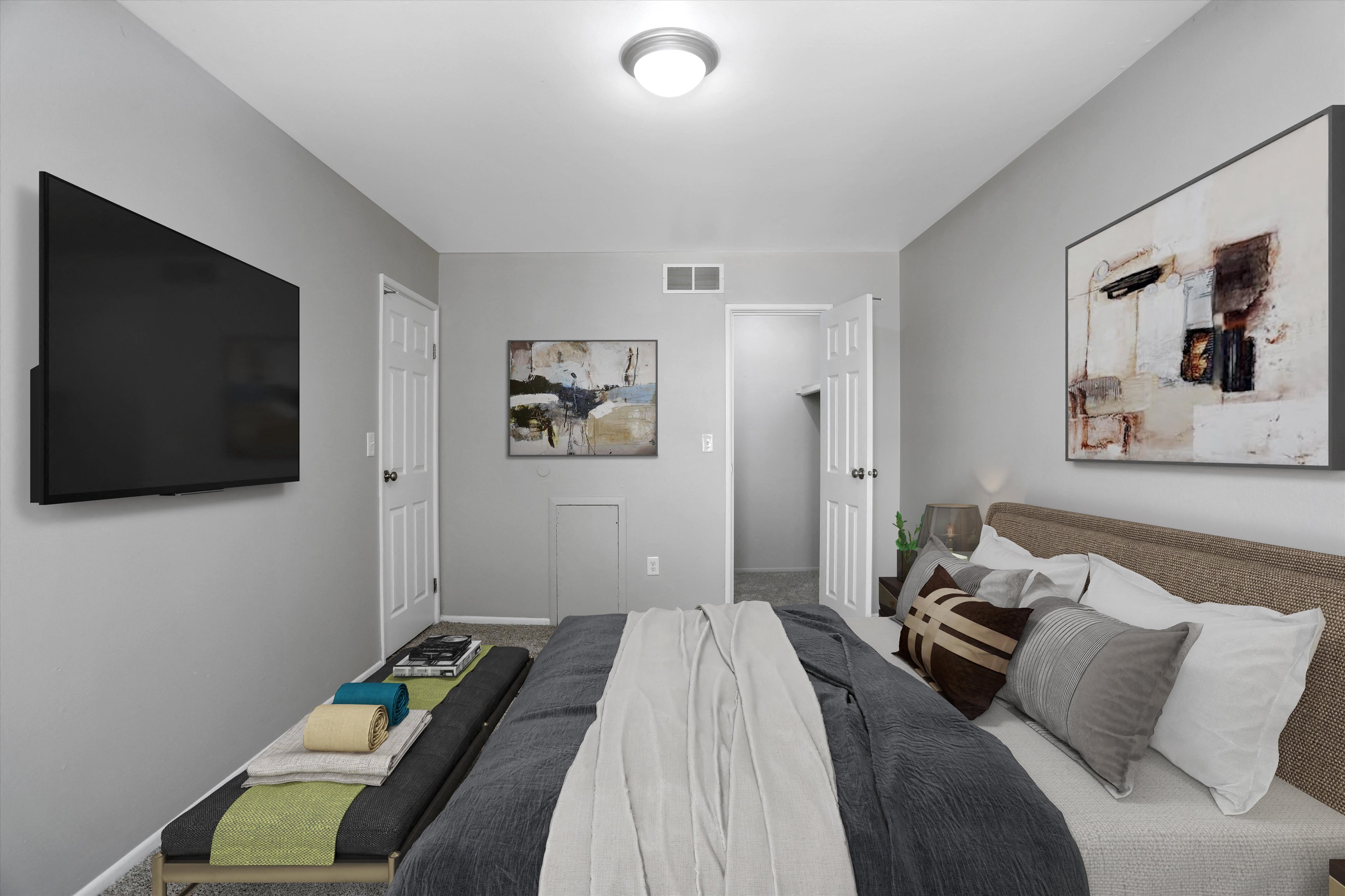 A bedroom with a bed in the center and a painting on the wall.