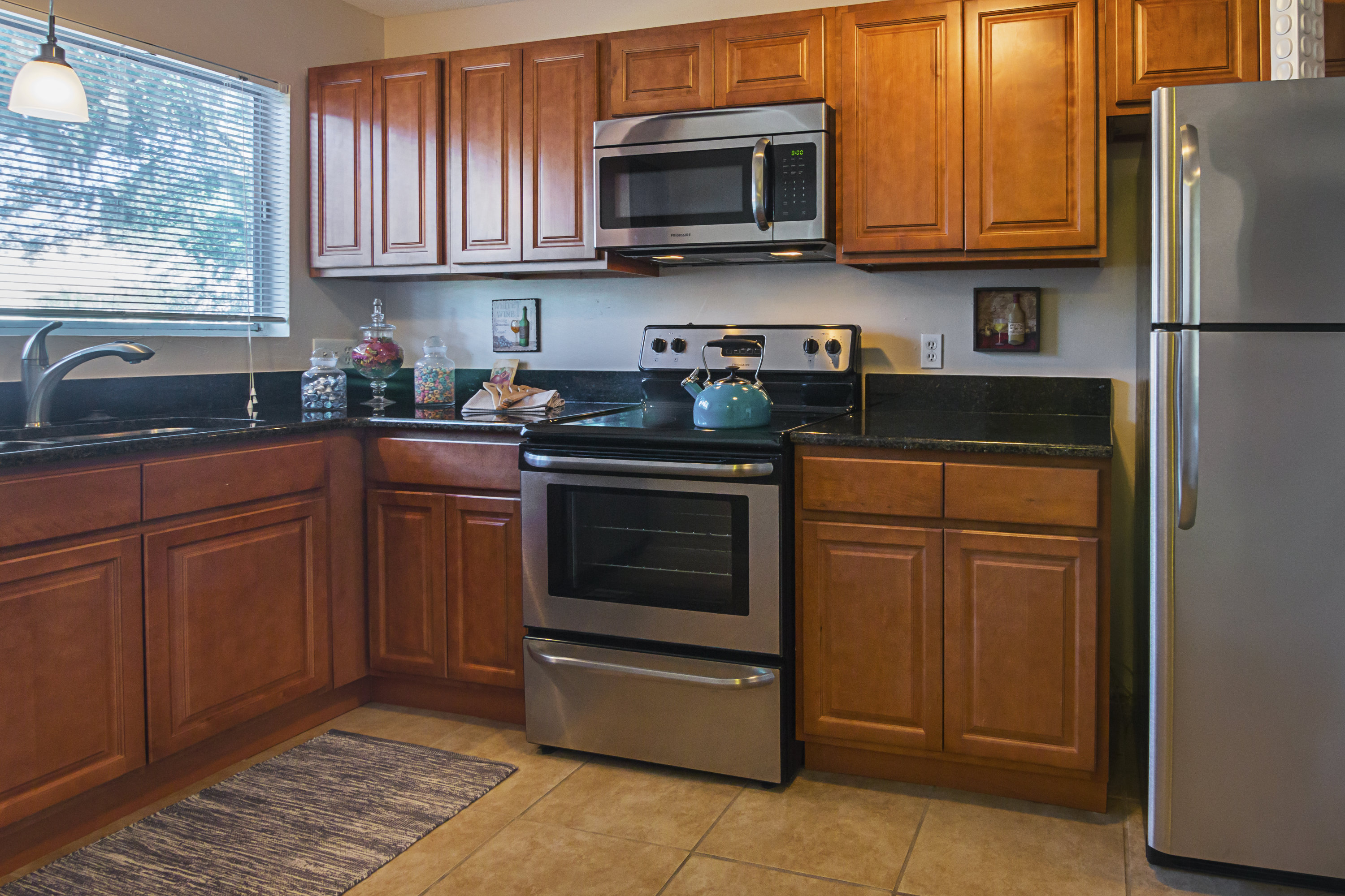 A kitchen with wooden cabinets and a stainless steel refrigerator.