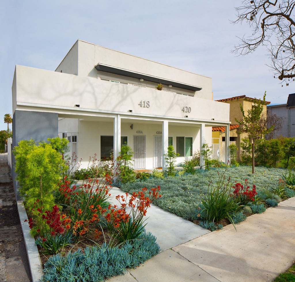 a white house with a garden in front of it