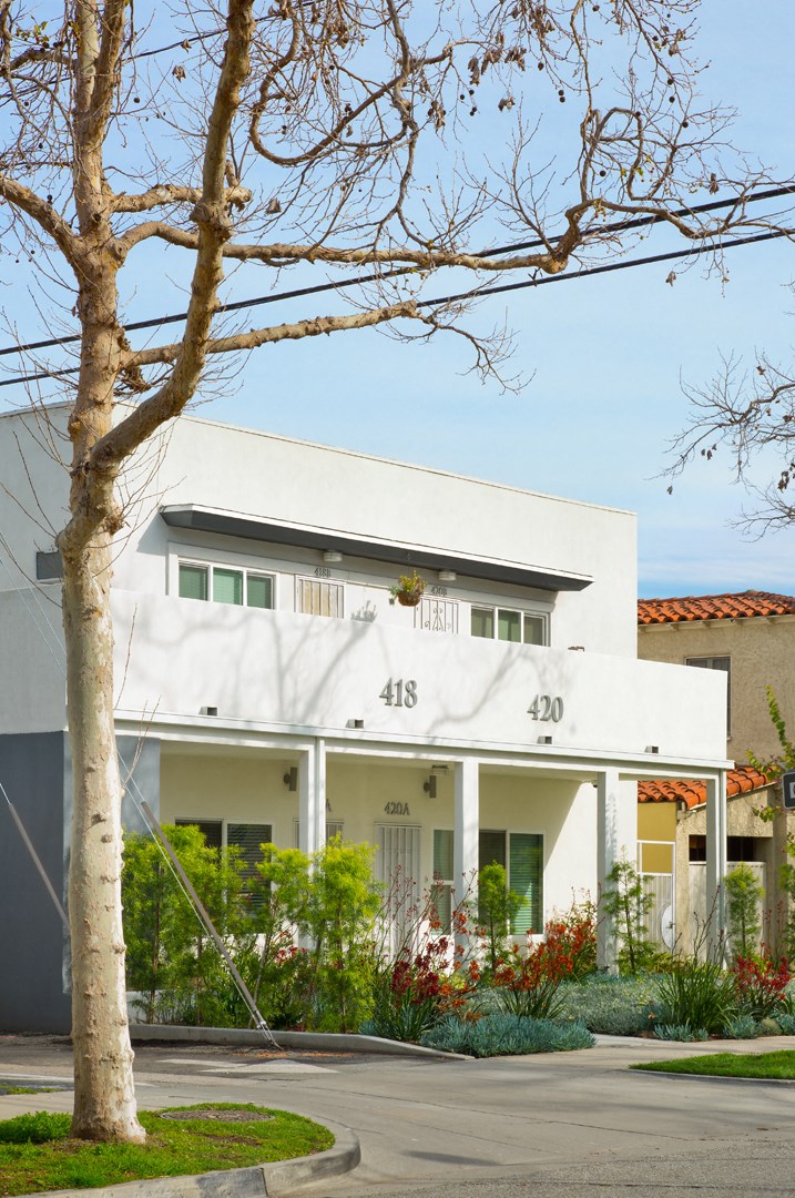 a white house with a tree in front of it